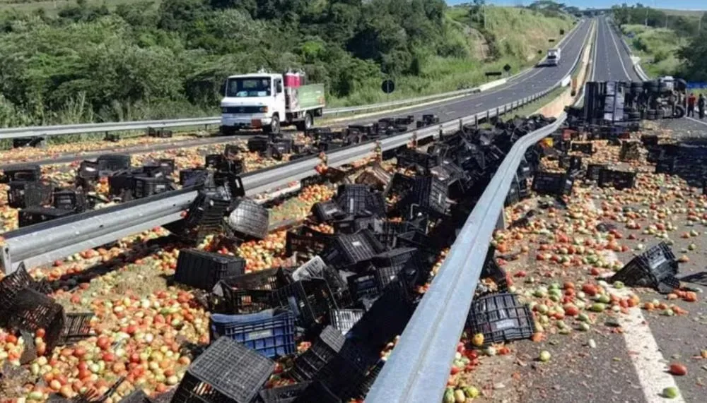 Carreta carregada com caixas de tomate tomba na rodovia e interdita trecho na região